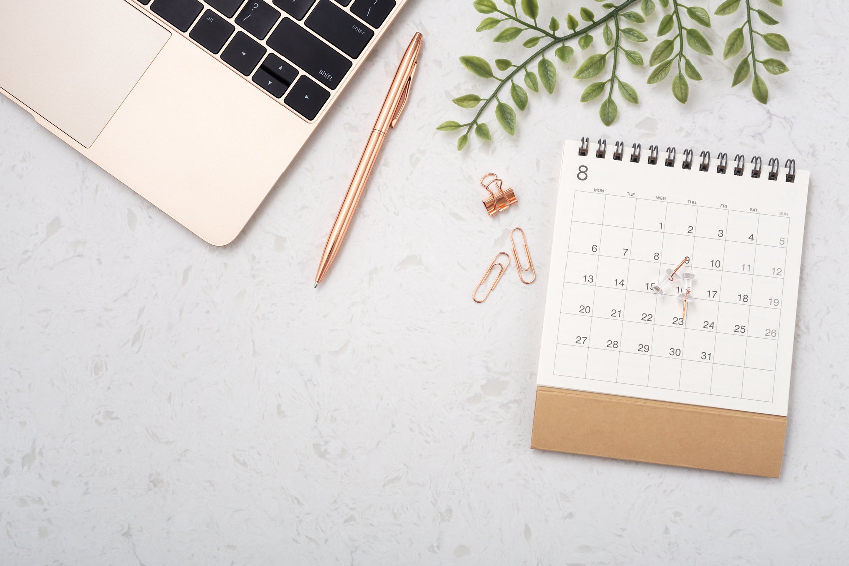 Calendar with laptop on white quartz table